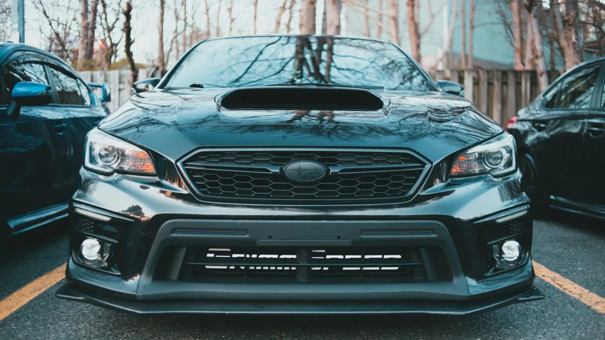 Radar sensor housing mounted behind a vehicle front grille