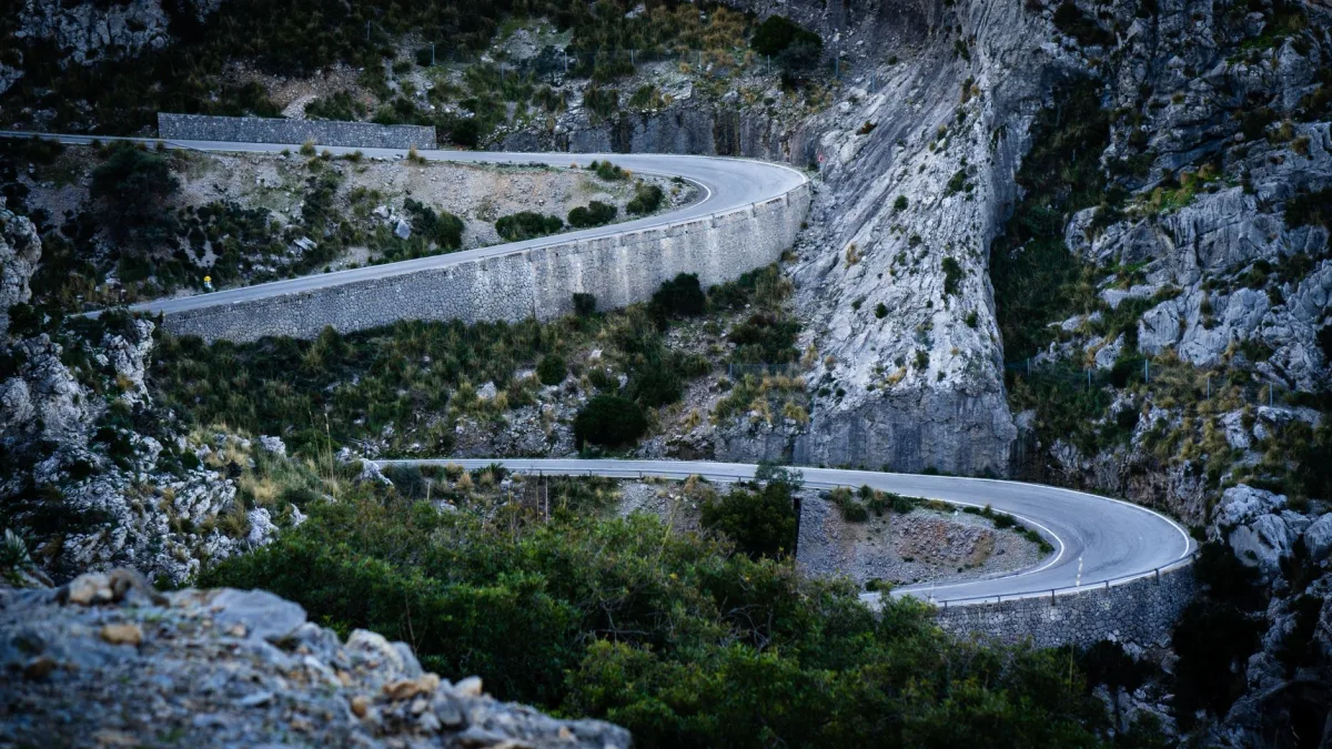 Two lane highway climbing a steep grade with a curve ahead