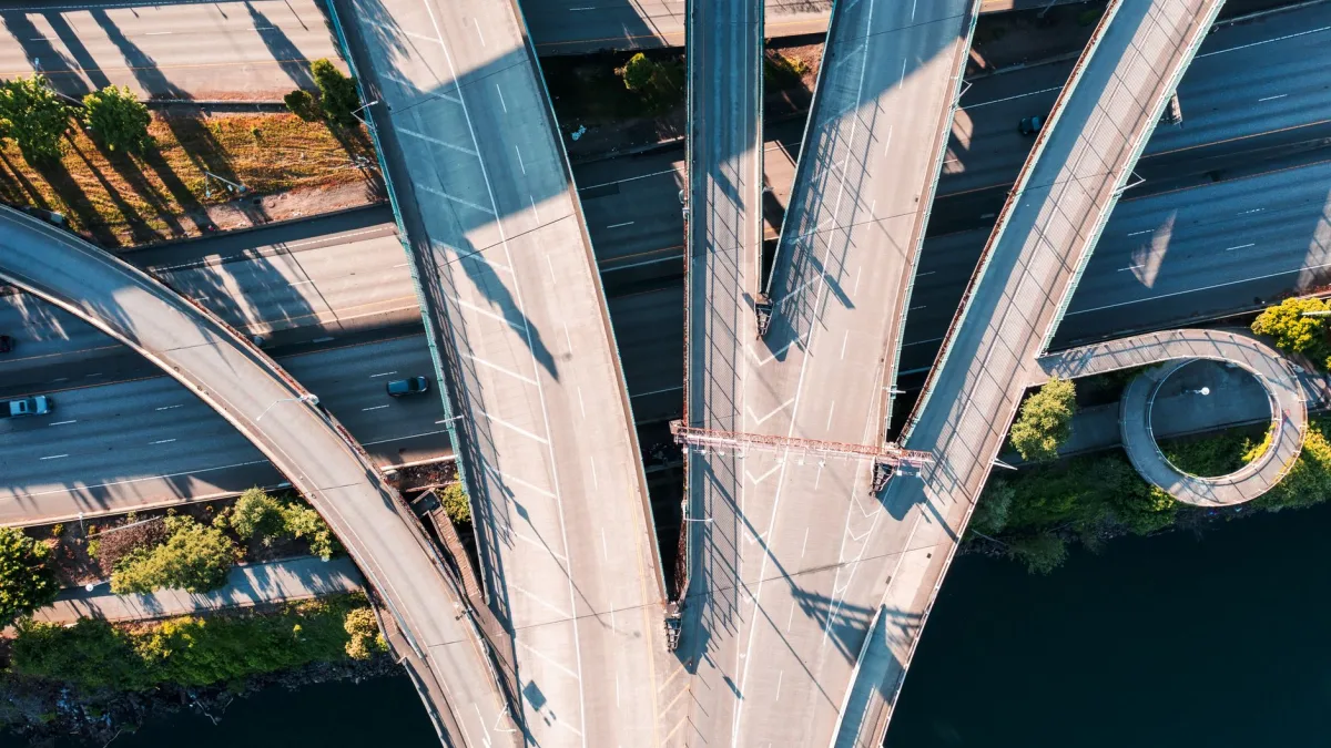 Highway approaching a concrete overpass on a clear multilane road