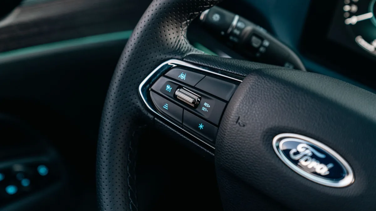 Close-up of steering wheel buttons with adaptive cruise distance controls