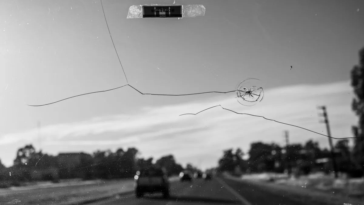A cracked windshield being assessed before replacement and recalibration