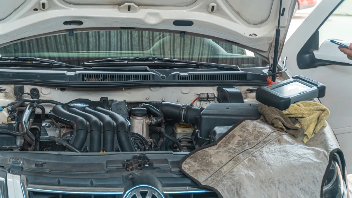 Independent shop technician using a diagnostic scan tool on a car