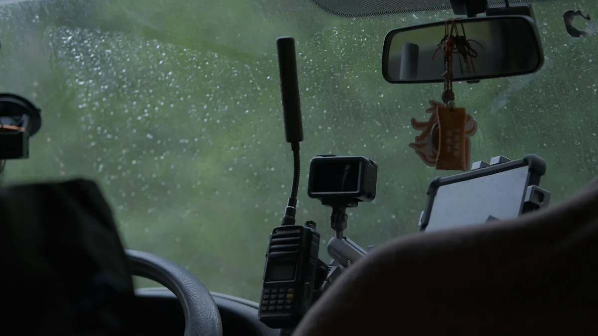 A grime coated windshield in front of a forward facing ADAS camera housing