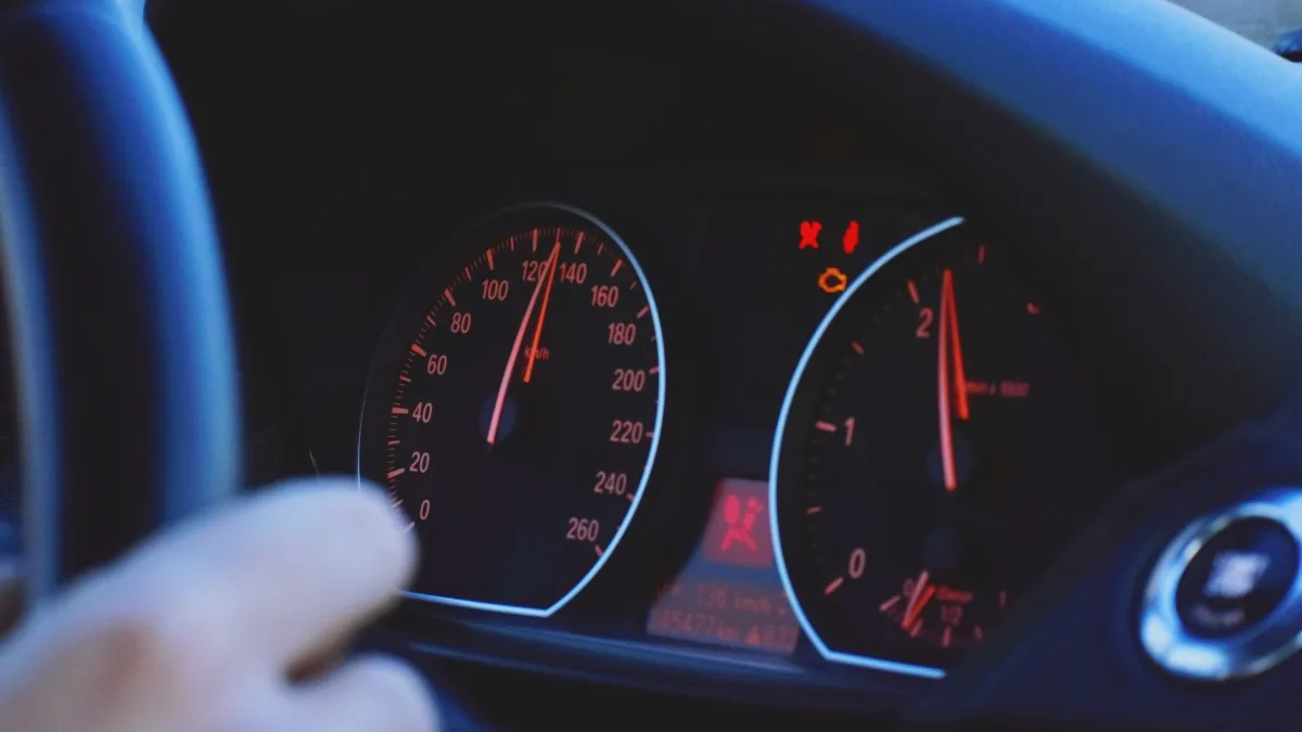 Red collision warning illuminated on a dashboard as a driver reacts