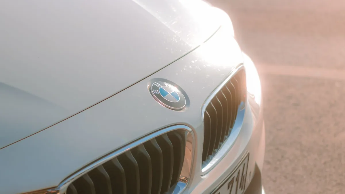 Front radar module mounted behind a vehicle grille emblem
