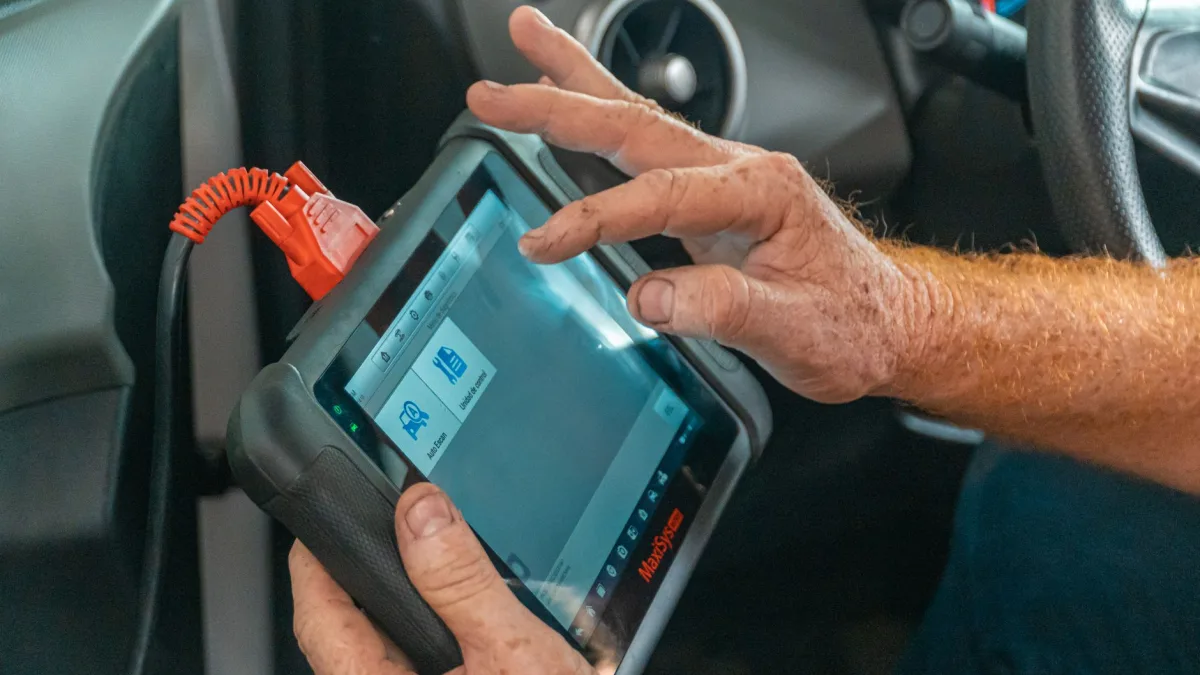 Technician connecting a scan tool to diagnose a blind spot module