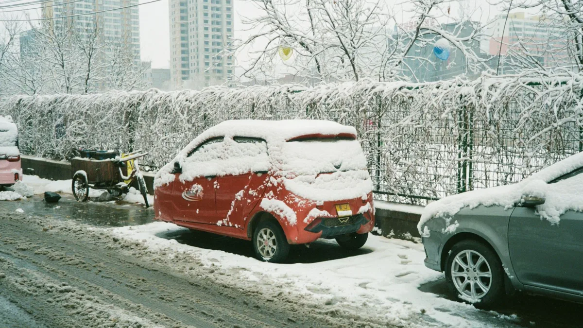 Brown winter slush packed across the rear corner of a car bumper