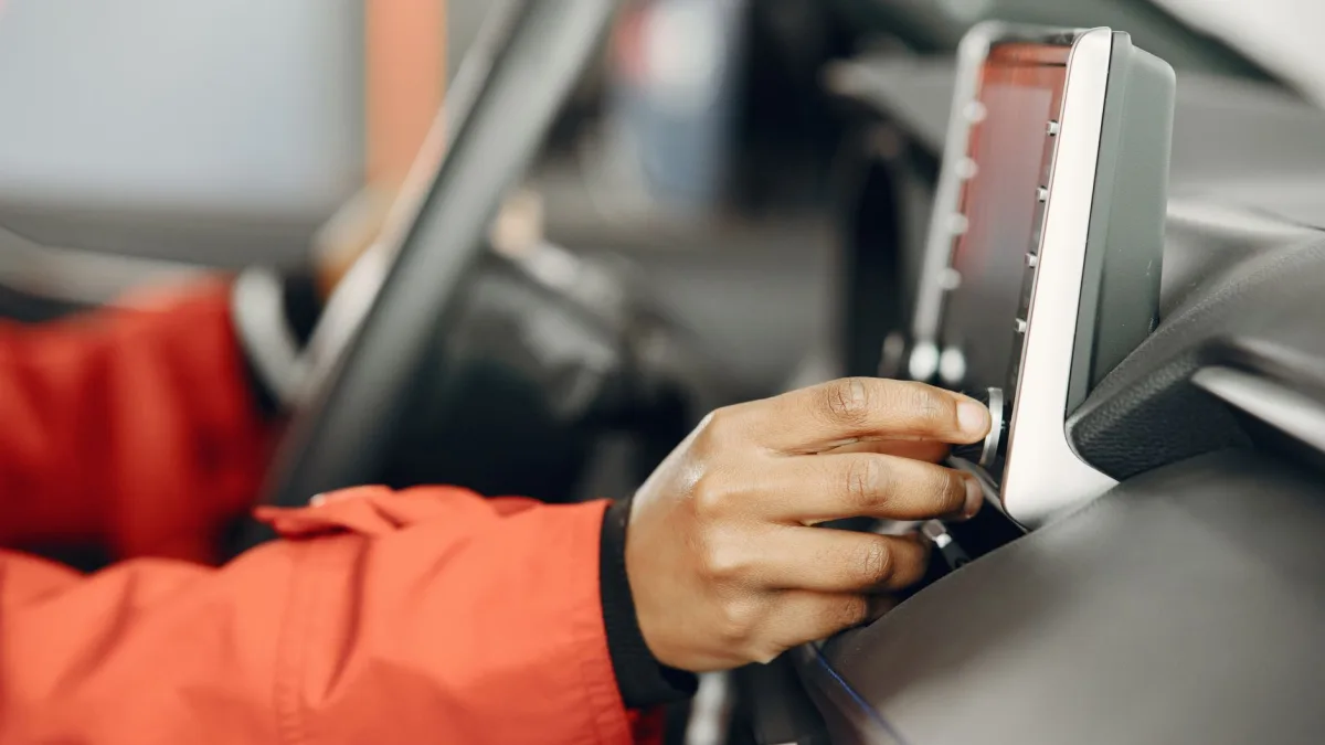 Driver reaching for the touchscreen menu to adjust driver assist settings