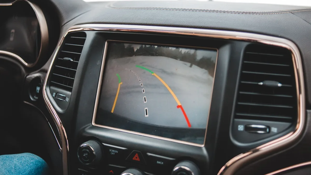 A compact driver-assist camera mounted at the top interior of a windshield
