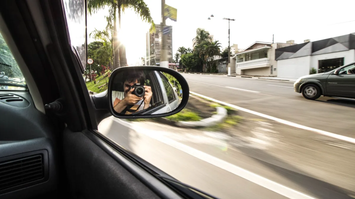 Wide-angle camera lens mounted on the underside of a side mirror housing