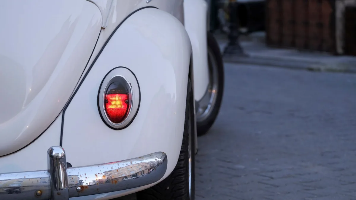 Close look at a round ultrasonic parking sensor set into a painted bumper