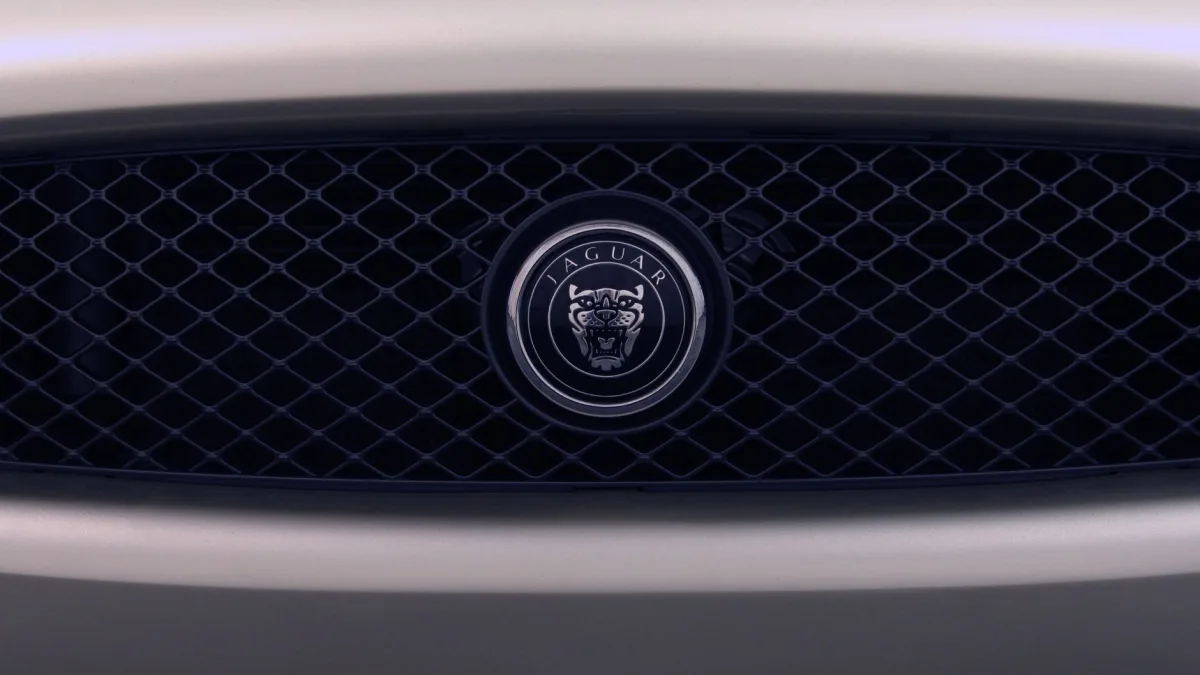 Front radar module mounted behind a vehicle grille emblem