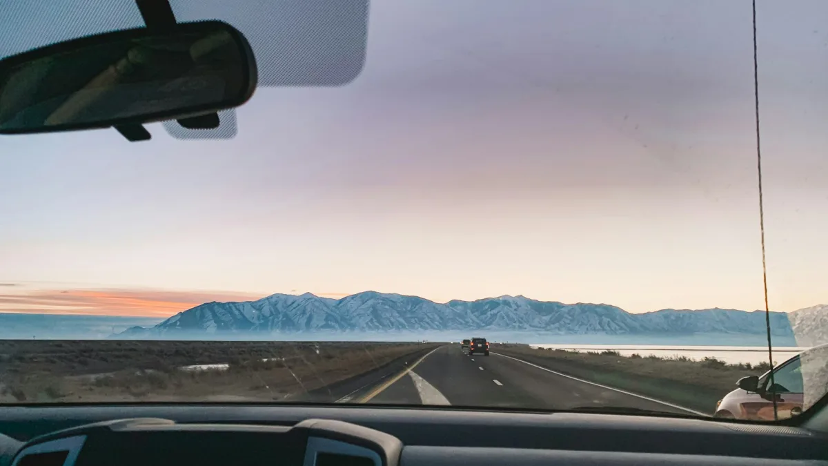 Low sun glaring across a windshield during evening highway driving