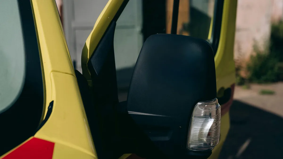 Amber blind spot indicator glowing in the corner of a Nissan side mirror