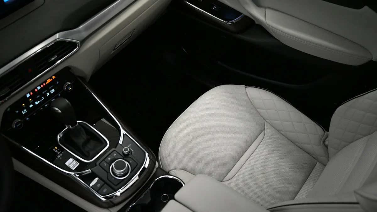 Lower dashboard buttons including a collision avoidance control near the gear selector